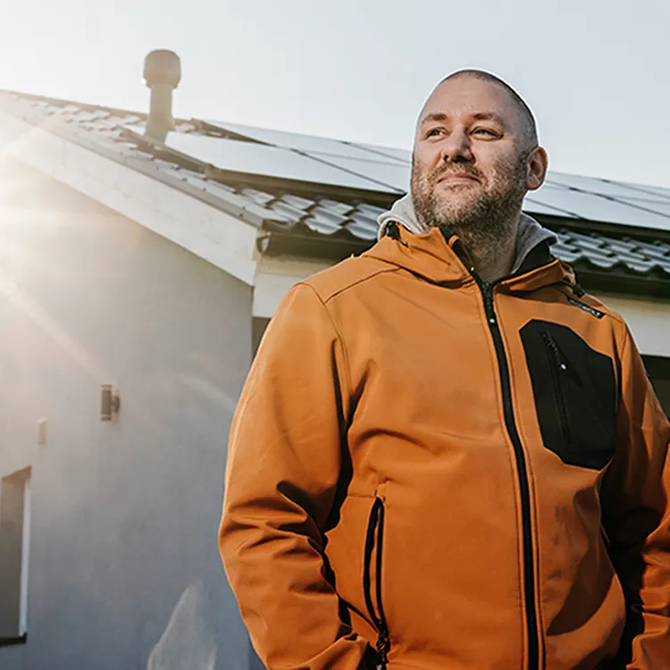 Glad man på bild framför solpaneler