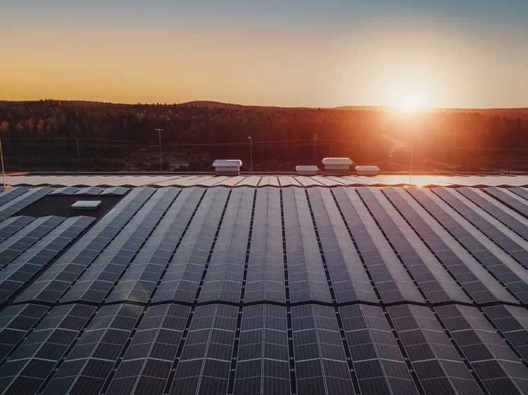 Große Photovoltaikanlage auf Gewerbedach bei Sonnenuntergang – nachhaltige Solarstromproduktion
