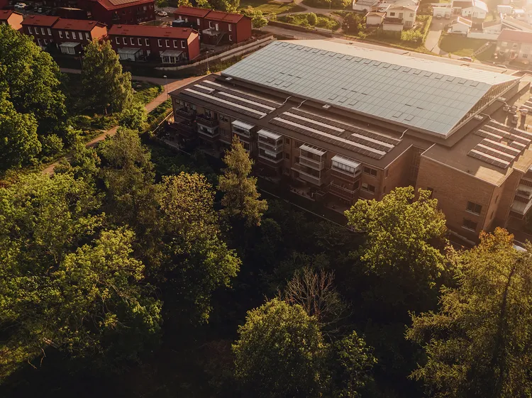 Luftaufnahme eines Gewerbegebäudes mit großer Photovoltaikanlage auf dem Dach – nachhaltige Solarstromproduktion