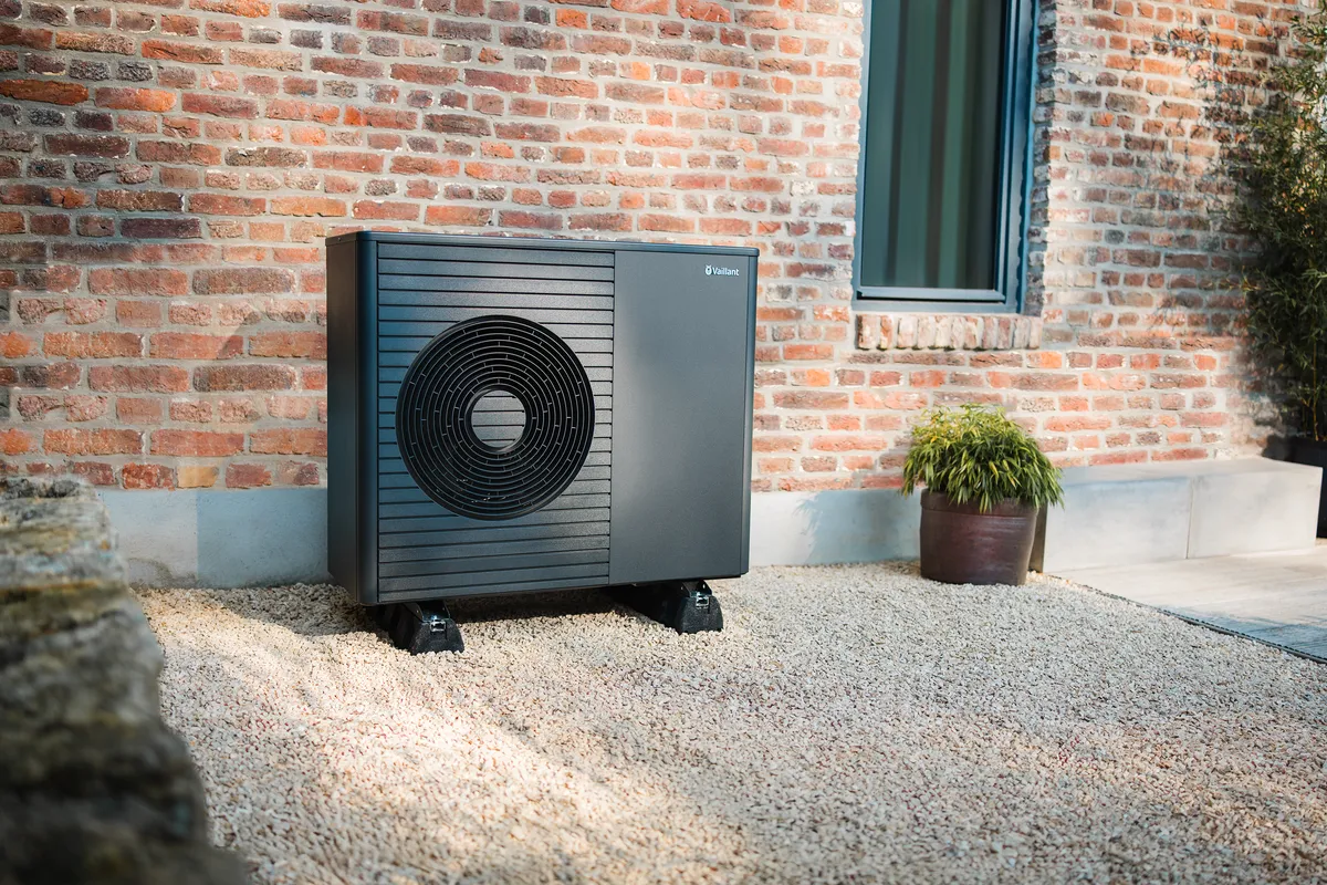 Wärmepumpe vor Hauswand aus Backstein – energieeffiziente Heizlösung mit erneuerbarer Energie