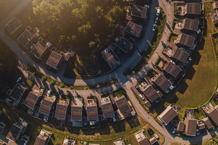 Luftaufnahme von Wohnsiedlung mit Photovoltaikanlagen auf Hausdächern – Solarstrom für nachhaltige Energie im Quartier
